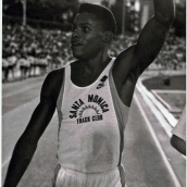 Carl Lewis, "El hijo del viento", Estadio Vallehermoso, Madrid, 4 de junio de 1987. Carl Lewis triunfó tanto en el esprint como en los relevos y en el salto de longitud. Fue doble campeón olímpico y el primer hombre en bajar de los 9,90 segundos en los 100 m. Su carrera se vio afectada por el escándalo de los Juegos de Seúl,1988, donde se le adjudicó la medalla de oro tras suspender al atleta canadiense Ben Johnson, que dio positivo por consumo de anabolizantes.